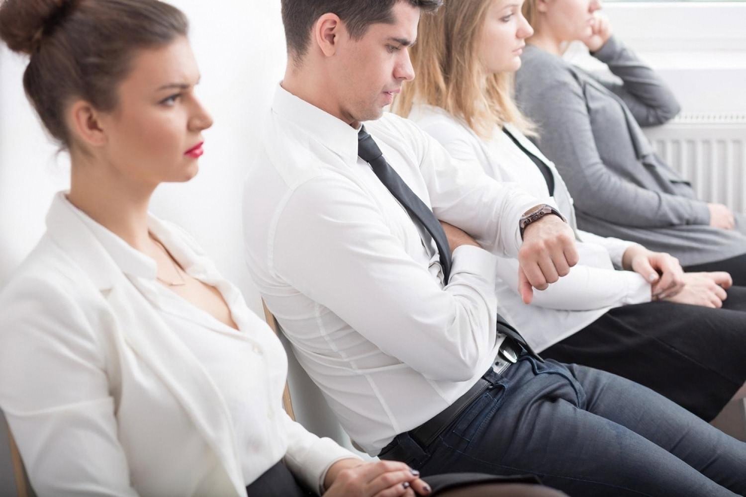 Frustrated customers sitting in a waiting area checking the time